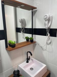ein Bad mit einem Waschbecken und einem Spiegel in der Unterkunft Studio 308 no Kobrasol à 7km de Floripa in São José