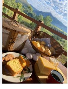 a table with a plate of bread and a basket of cheese at Pousada Chales da Canastra in Vargem Bonita