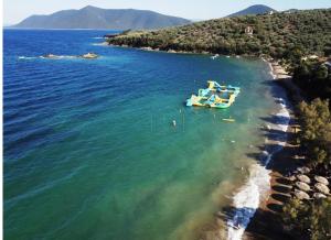 un barco en el agua junto a una playa en Theoxenia, en Pteleós