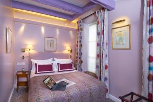 a bedroom with a large bed and a large window at Le Relais Montmartre in Paris