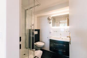 ein Bad mit einem WC, einem Waschbecken und einer Dusche in der Unterkunft Hotel Hasenjäger in Einbeck