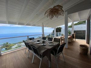 - une table à manger sur une terrasse couverte offrant une vue sur l'océan dans l'établissement Le Belvédère, à Saint-Leu