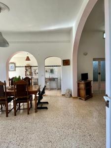 ein Esszimmer mit einem Torbogen, einem Tisch und Stühlen in der Unterkunft Wundervolles Ferienhaus in Apulien mit viel Platz in San Pietro in Bevagna