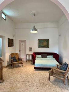 ein Schlafzimmer mit einem Bett, einem Sofa und einem Stuhl in der Unterkunft Wundervolles Ferienhaus in Apulien mit viel Platz in San Pietro in Bevagna