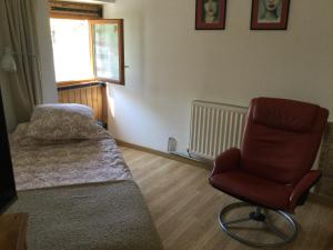 um quarto com uma cama, uma cadeira e uma janela em Tiny Acorns chambre d’hôte em Darnac