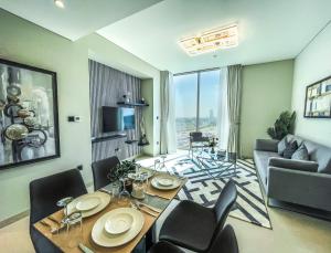 een woonkamer met een tafel en stoelen en een bank bij STAY BY LATINEM 2BR Holiday Home CV B514 near Burj Khalifa in Dubai