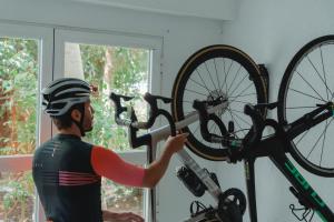 a man is holding a bike on a wall at Aparthotel Ses Fotges in Playa de Muro