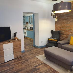 a living room with a couch and a flat screen tv at Jégmadár Apartman in Debrecen