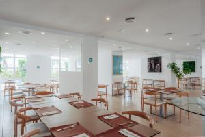 a room with tables and chairs in a building at Aparthotel Ses Fotges in Playa de Muro