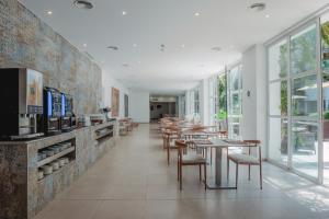 a restaurant with tables and chairs and windows at Aparthotel Ses Fotges in Playa de Muro