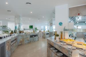 a large kitchen with many plates of food at Aparthotel Ses Fotges in Playa de Muro