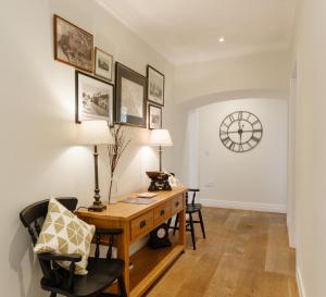 biuro domowe z biurkiem i zegarem na ścianie w obiekcie The Walled Garden at Woodhall Estate w mieście Hertford