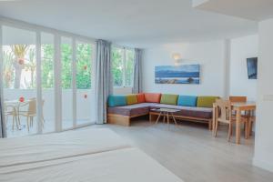 a living room with a couch and a table at Aparthotel Ses Fotges in Playa de Muro