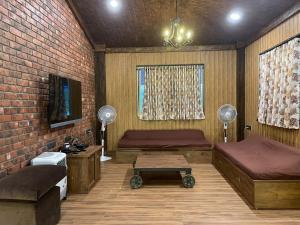 a living room with two beds and a table at Cold Spot Village Resort in Mahabaleshwar