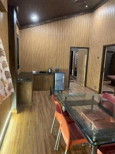 Cold Spot Village Resort في ماهاباليشوار: غرفة طعام مع طاولة وكراسي زجاجية