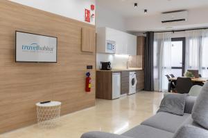 ein Wohnzimmer mit einem TV an der Wand in der Unterkunft Travel Habitat La Marina Real in Valencia