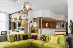 a living room with a green couch and balls at Holiday Inn Düsseldorf-Neuss, an IHG Hotel in Neuss