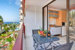 einen Balkon mit einem Tisch und einer Obstschale in der Unterkunft ON THE BEACH, Sea View, Fast Fiber, Pool, Parking in Playa de las Americas