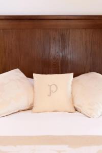 a bed with two pillows with the letter p on it at Hotel & Restaurant Pahor in Doberdò del Lago