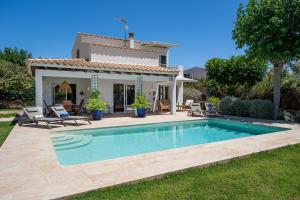 a swimming pool in front of a house at Villa El Olivo Menorca in Binisafua