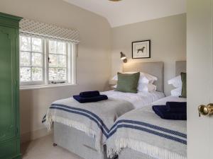 1 dormitorio con 2 camas y toallas azules. en The Walled Garden at Woodhall Estate, en Hertford