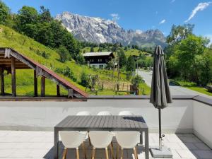 a table with chairs and an umbrella on a roof at Apartment in Dienten near Gabühel Ski Lift in Dienten am Hochkönig