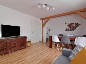a living room with a television and a table and chairs at Apartment in Dienten with mountain view and HochkönigCard in Dienten am Hochkönig
