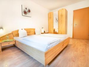 a bedroom with a large bed with a wooden headboard at Attractive Apartment in Stubaital with Ski Boot Heaters in Neustift im Stubaital