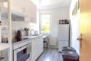 a white kitchen with a refrigerator and a sink at Modern Apartment in Lüdenscheid in Lüdenscheid