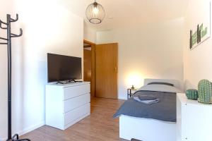 a bedroom with a bed and a flat screen tv at Modern Apartment in Lüdenscheid in Lüdenscheid