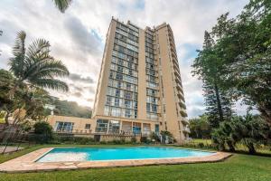 a building with a swimming pool in front of a building at 1002 La Ballito-trendy apartment with endless view in Ballito