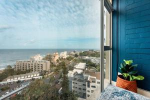 a window with a view of a city and the ocean at 1002 La Ballito-trendy apartment with endless view in Ballito