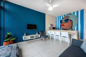 a living room with a blue wall with a painting of a woman at 1002 La Ballito-trendy apartment with endless view in Ballito