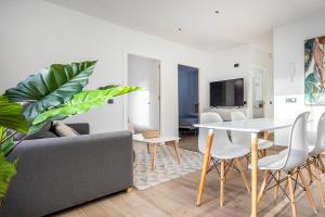 a living room with a table and a couch at Nervión Suites 1 - Vacacional Sevilla in Seville