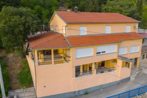 a yellow house with a red roof at HOLIDAY HOME IVA, Proložac - Makarska in Donji Proložac
