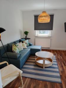 a living room with a blue couch and a table at Estupendo apartamento con vistas 2B in Grünberg