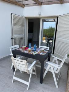 czarny stół i krzesła na patio w obiekcie Villa GEGI w mieście Budoni