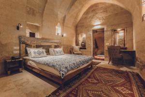 a bedroom with a bed in a large room at La maison de Şişik in Uchisar