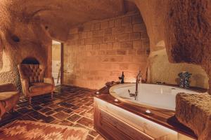 a large bathroom with a tub and a chair at La maison de Şişik in Uchisar