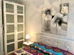 1 dormitorio con 1 cama y una pintura en la pared en Paradise Apartment Malcesine en Malcesine
