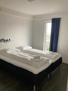ハウゲスンにあるFlotmyrgården Apartment Hotelの窓付きの客室の大型ベッド1台分です。