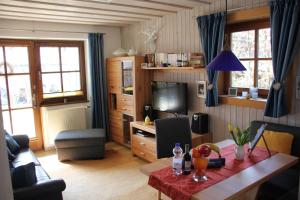 ein Wohnzimmer mit einem Tisch und einem TV in der Unterkunft Ferienwohnung Schauberger in Oberammergau