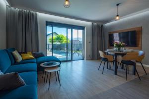 a living room with a blue couch and a table at Apartament Widok in Piechowice