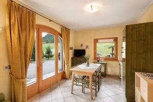 une cuisine avec une table et des chaises ainsi qu'une fenêtre dans l'établissement Terra Chalet Martina, à Livigno