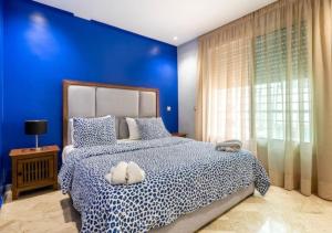a blue bedroom with a bed with a blue wall at Superbe appartement 2 chambres Maarif Val Fleuri in Casablanca