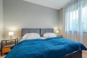 a bedroom with a large bed with a blue comforter at Apartament Widok in Piechowice