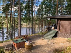 a log cabin with a bench and a picnic table at Kesämökki Kalliola Heinola in Ahvenisto