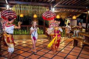 three girls are standing in a restaurant with umbrellas at Nick's Pension in Ubud