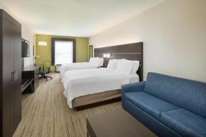 a hotel room with two beds and a couch at Holiday Inn Express Hotel & Suites Port Richey, an IHG Hotel in Port Richey