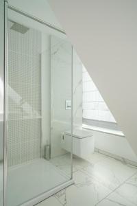 uma casa de banho com uma cabina de duche em vidro e um lavatório. em Apartamenty na Kazamatach 24 Old Town Wroclaw em Breslávia